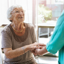A caregiver assisting a smiling patient